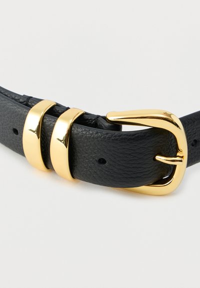 Ceinture en cuir texturé noir avec une boucle rectangulaire dorée brillante et deux passants dorés sur fond blanc.