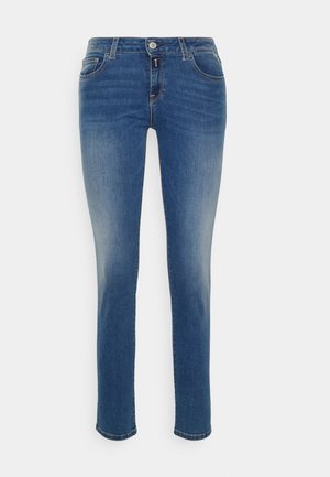 Jeans in denim blu a vestibilità slim con vita media, cinque tasche e chiusura con bottone. Texture sbiadita lungo le gambe esterne e gli orli.