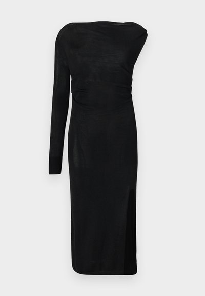 Ασύμμετρο μαύρο πλεκτό φόρεμα με ένα μακρύ μανίκι, σούρες στη μέση και σκίσιμο στο μηρό δεξιά.