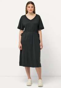 Robe midi gris foncé avec un décolleté en V, manches courtes, taille froncée et accents à cordon ; fabriquée à partir d'un tissu doux et texturé.