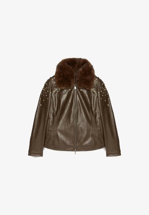 Giubbotto in pelle marrone con colletto in pelliccia sintetica, decorazioni borchiate sulle spalle e chiusura con zip. Texture morbida e design aderente.
