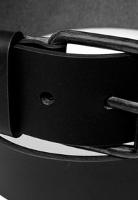 Ceinture en cuir noir avec une finition texturée, dotée d'une boucle en métal et de plusieurs trous de réglage pour la taille. Serrée autour d'une boucle.