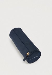 Κυλινδρική θήκη με φερμουάρ σε ναυτι κό μπλε χρώμα, κατασκευασμένη από υφή υφάσματος, με χρυσά μεταλλικά στοιχεία και λογότυπο στη βάση. Κατάλληλη για αξεσουάρ ή μικρά αντικείμενα.