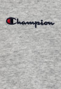 Gray cotton fabric with a textured finish, featuring the word "Champion" embroidered in navy with a red accent on the 'C'.