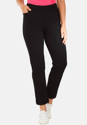 Schwarze Hose mit elastischem Bund und zwei Vorderaschen. Gerades Bein-Design mit glatter Textur, kombiniert mit weißen Sneakers.