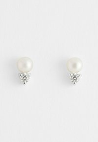Orecchini a perla rotondi con un accento in zirconia cubica, montati in metallo tono argento. Texture liscia con una finitura lucida.