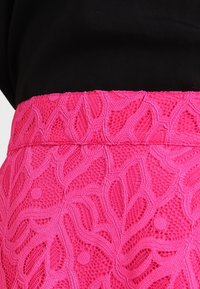 Kirkkaansininen pitsihame kukkakuviolla, yhdistettynä mustaan paitaan.