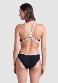 Černý bikini s šedými a bílými pruhovanými akcenty; má křížové ramínka na zádech a hladkou texturu.