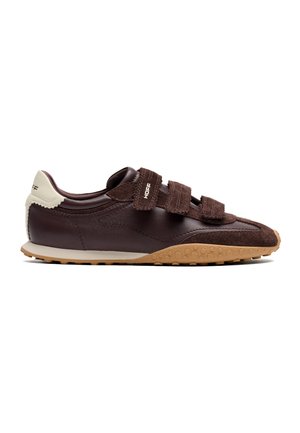 Ciemnobrązowy sneaker z trzema paskami na rzepy, beżową zakładką na pięcie i gumową podeszwą z sześciokątnym wzorem.