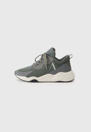 Sport sneakers met een mix van donkergroen gaas en grijze accenten, met een dikke witte tussenzool en grijze veters. Afgeronde neus en gevoerde kraag.