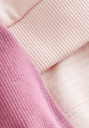 Échantillons de textiles en rose clair et mauve, présentant des textures côtelées et lisses. Les détails de couture visibles renforcent la structure du tissu.