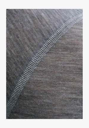 Pelēka tekstila virsma ar mīkstu tekstūru un smalku austu rakstu. Balta šuvuma odere pie vīles pievieno detaļas un kontrastu.