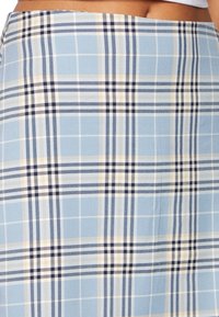 Blå rutiga kjol i lättviktsmaterial med marinblå och krämfärgade ränder. Designen har en strukturerad form och ett exakt rutmönster.