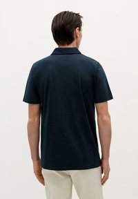 Námořnická polo košile vyrobená z měkké bavlny, s klasickým límcem a krátkým rukávem, rovného střihu a minimalistickým designem.
