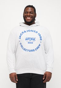 Helles graues Kapuzensweatshirt aus weichem Material, mit einem großen blauen runden Grafikdesign mit Text und Logos auf der Vorderseite.
