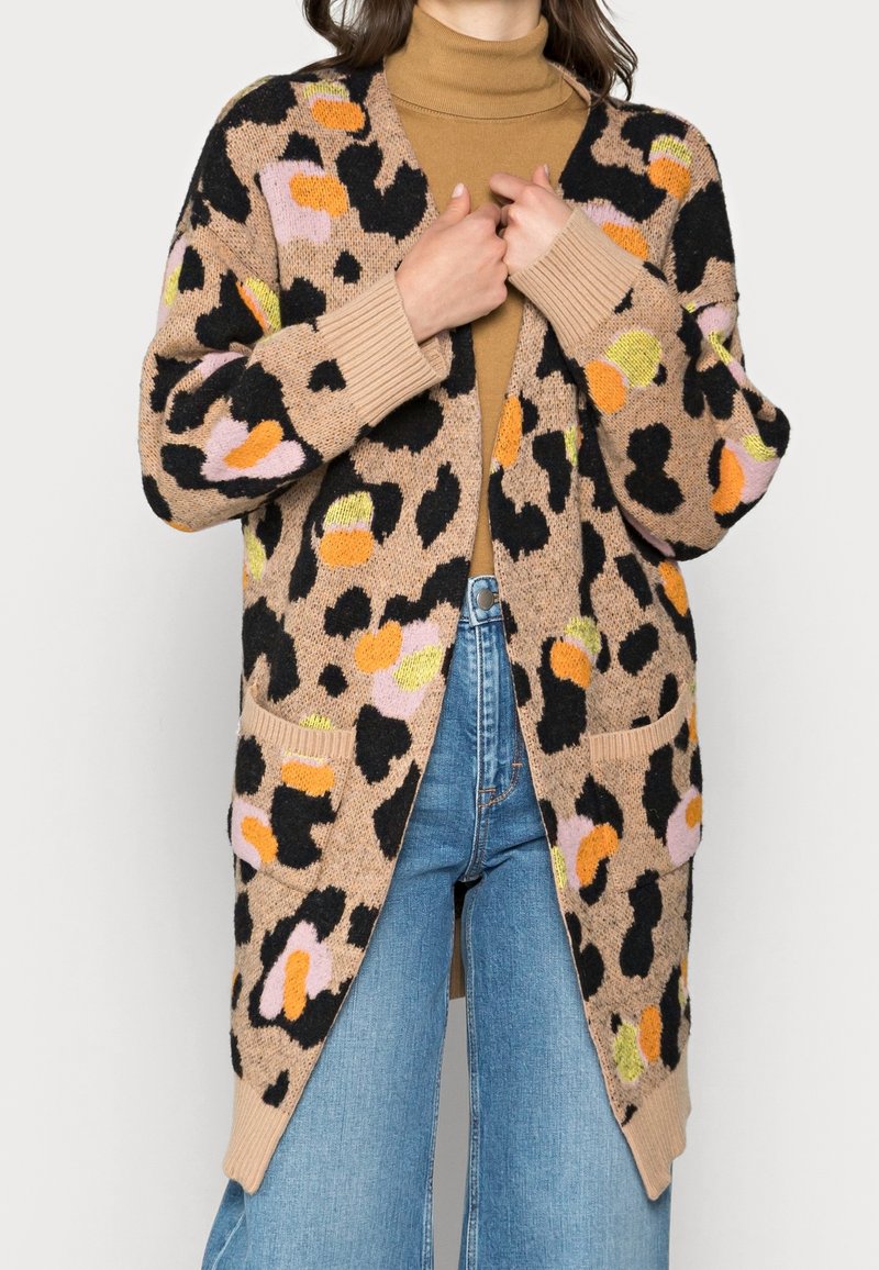 Kardigan w cętki lamparta w kolorze jasno-brązowym, z wielokolorowymi plamkami (czarne, pomarańczowe, różowe, żółte), ściągaczami na mankietach i bocznymi kieszeniami.