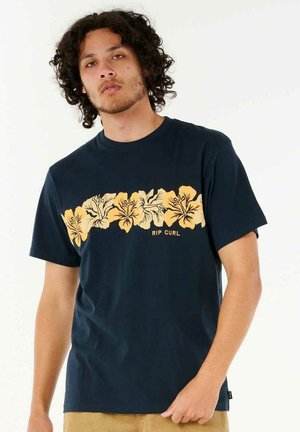 Marineblaue Baumwoll-T-Shirt mit einem gelben Hibiskus-Blumenmuster auf der Vorderseite, mit dem Text "RIP CURL" unter dem Design. Kurze Ärmel und Rundhalsausschnitt.