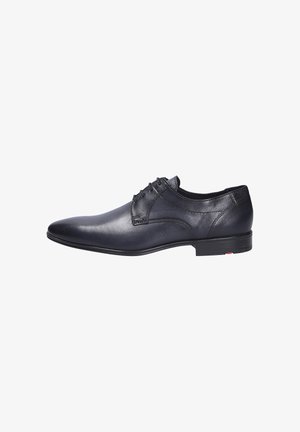Schwarze Leder-Oxford-Schuhe mit glatter Oberfläche, spitzem Zehenbereich, fünf Ösen und niedrigem gestapeltem Absatz. Dezente Stichdetails und Logo-Akzent.