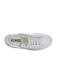 White leather sneaker with gray accents, flat laces, perforated details, and a padded tongue. Features brand logo on insole and side.