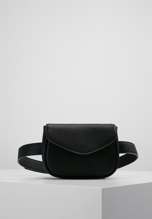 Sac banane en cuir noir avec fermeture à rabat avant présenté sur un piédestal blanc sur fond gris uni.