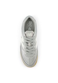 Gray and white New Balance RC 4 sneaker with laces, visible logo on tongue and side, and gum sole viewed from above.