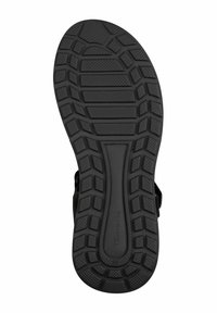 Černá gumová podrážka sandálů s texturovaným vzorem podrážky, který obsahuje hluboké drážky a vyvýšené sekce pro lepší trakci. Odolný a flexibilní design.