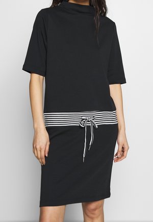 Robe noire avec un col en entonnoir, des manches courtes et une ceinture à rayures. Le tissu semble lisse et respirant.
