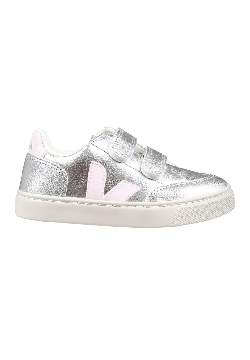 Sapatilha metálica prateada com detalhes em rosa, duas tiras de Velcro, sola branca, textura suave e um logó tipo no calcanhar.