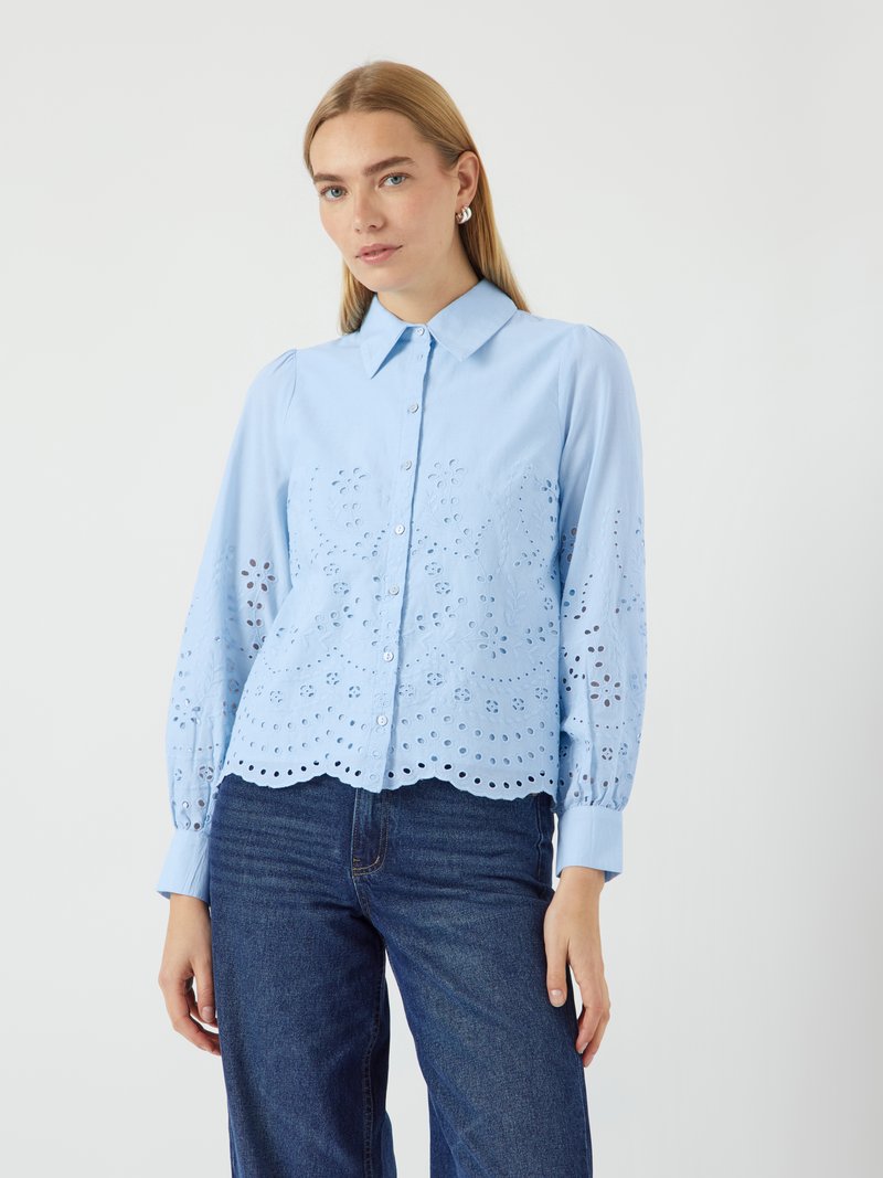 Light blue blouse with embroidered eyelet detailing, scalloped hem, and button closure. Long puff sleeves and collared neck design.