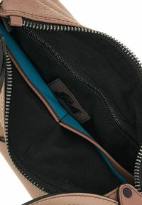 Bruine leren tas met een interieur van zwarte stof en blauwe accenten, uitgerust met een ritssluiting en een klein label in de binnenkant.
