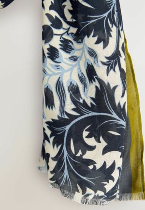 Foulard avec de grands motifs floraux bleu foncé et bleu clair sur un tissu blanc, montrant une couche de tissu vert en dessous.