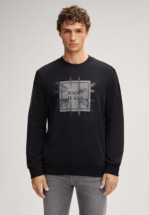 Schwarzer Sweatshirt mit rundem Halsausschnitt, langen Ärmeln und einem grauen Frontdruck mit dem Text "JOOP! JEANS" in einem quadratischen Design.