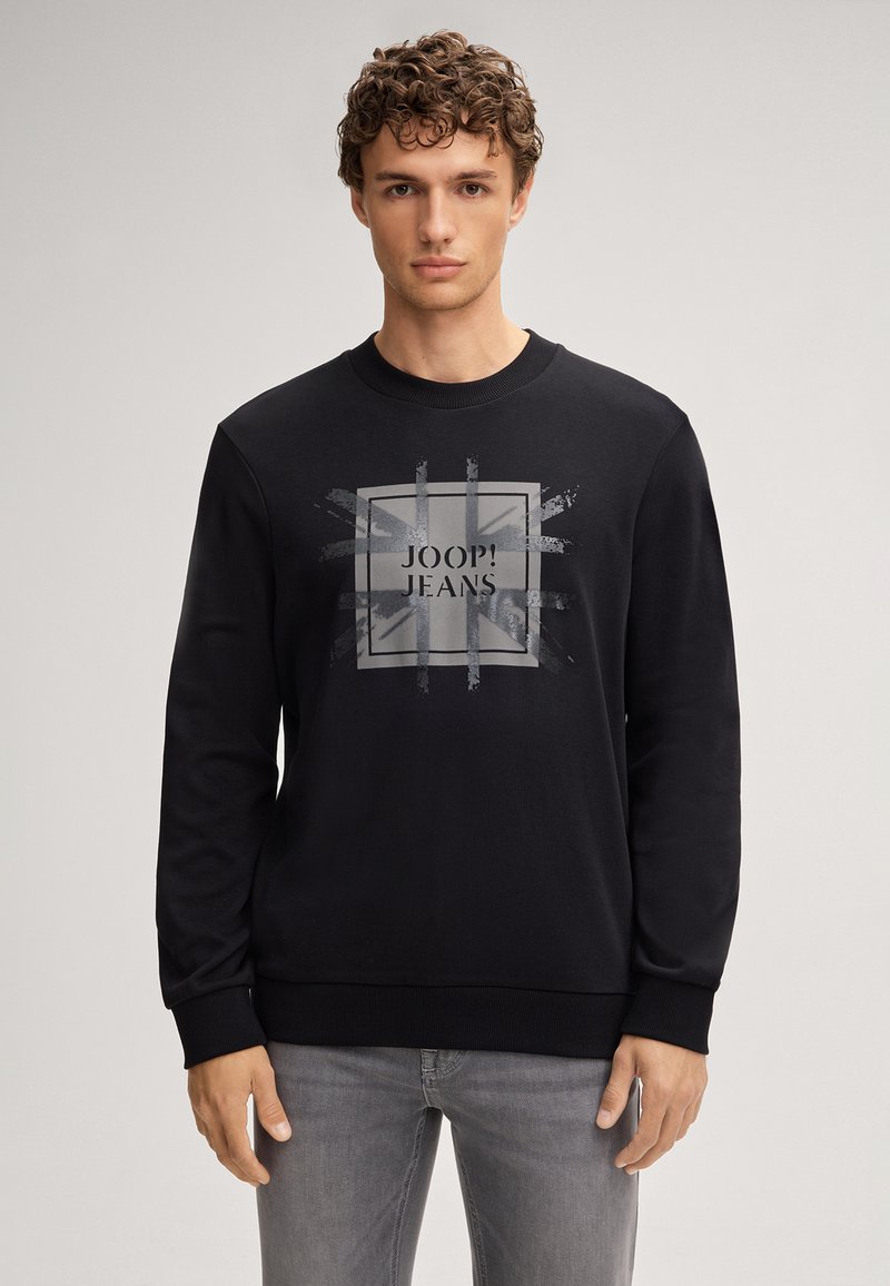 Felpa nera con collo rotondo, maniche lunghe e una grafica frontale grigia con il testo "JOOP! JEANS" all'interno di un design quadrato.
