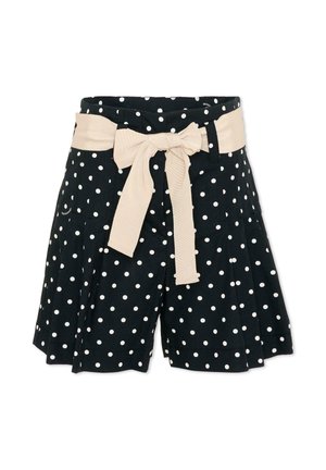 Pantaloncini neri con pois bianchi e una larga cintura di tessuto beige annodata a fiocco in vita.