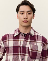 Rutet skjorte i burgunder og krem, laget av myk stoff. Har klassisk krage, frontknapper og en brystlomme. Strukturerte mønster.