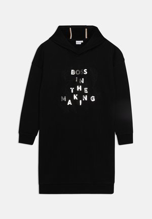 Zwarte lange mouw hoodie jurk met zilveren tekst "BOSS IN THE MAKING" en subtiele veerontwerpen op de voorkant.