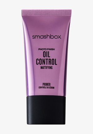 Smashbox Photo Finish Oil Control Matterende Primer in een glanzende paarse tube met zwarte dop, ontworpen om gezichtsolie en glans te verminderen.