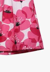 Blumendruckstoff mit großen rosa Mohnblumenmustern, schwarzen Mitten und weißen Akzenten. Weiche Textur mit gesäumtem Rand.