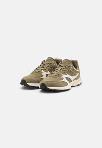 Olivengrønne sneakers med ruskind og mesh-detaljer, hvide accenter, rund tå og sort gummisål. Har snørebåndsdesign og polstret krave.