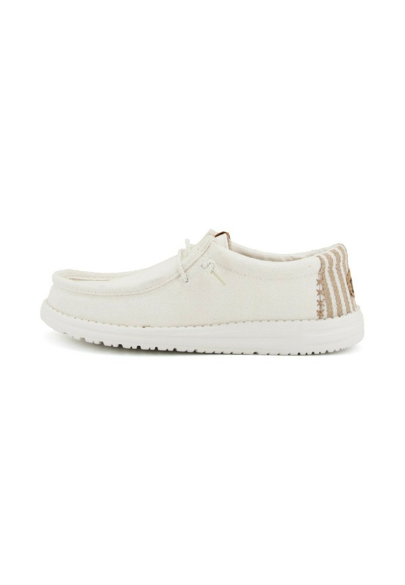Scarpa in tela di colore bianco sporco con tomaia testurizzata, punta tonda, chiusura con lacci e accenti a righe sul tallone. Suola in gomma.