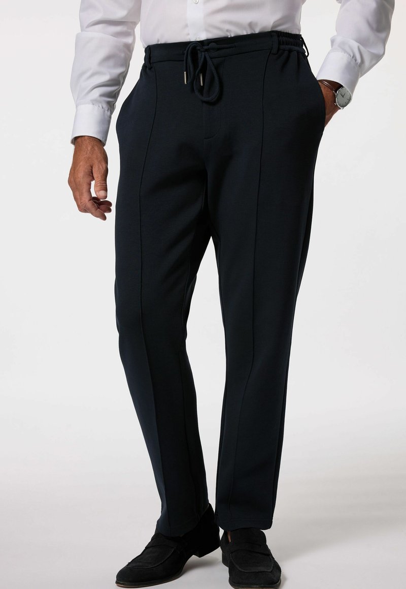 Tummansinisen sävyiset nyörivyötöiset housut, joissa on sileä tekstuuri, sivupintatikkaukset ja joustava vyötärö mukavuutta varten.