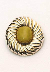 Gouden broche met een centraal olijfgroene steen, omringd door gestileerde, gestructureerde bladachtige accenten. Ronde vorm met een reflecterend oppervlak.