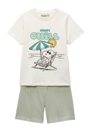 T-shirt blanc avec Snoopy allongé sur une chaise de plage sous un parasol, accompagné du texte « Snoopy Chill », associé à un short vert clair.