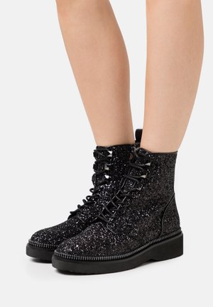 Bottes cheville pailletées noires avec bout arrondi, dotées d'un laçage à l'avant, d'une tige texturée et d'une semelle en caoutchouc avec coutures décoratives.