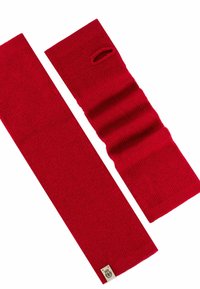 Red knitted scarf, featuring a ribbed texture with an open hole design on one end, and a label with logo at the base.