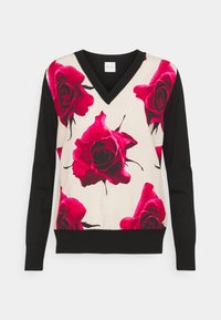 Pull en V avec manches noires et devant crème orné de grandes impressions de roses rouges. Tissu doux avec un contraste de couleurs.