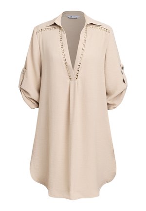 Beige tuniek met lange mouwen, V-hals, gehaakte kanten boord en mouwen met knoopje, gemaakt van gestructureerde stof.