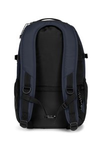 Zaino in tessuto blu navy con dettagli neri, schienale imbottito, spallacci regolabili e tasche laterali. Presenta una texture liscia e ferrature resistenti.