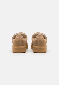 Sapatos slip-on de camurça em tom de areia com um fundo texturizado, colarinho almofadado e solado em borracha. Apresenta costura horizontal e um design de bico arredondado.