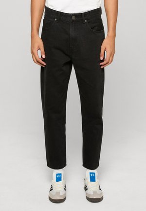 Čierne džínsy s rovnými nohavicami, vybavené prednými vreckami, pútkami na opasok a klasickým zapínaním na vrchný gombík. Neformálny strih.